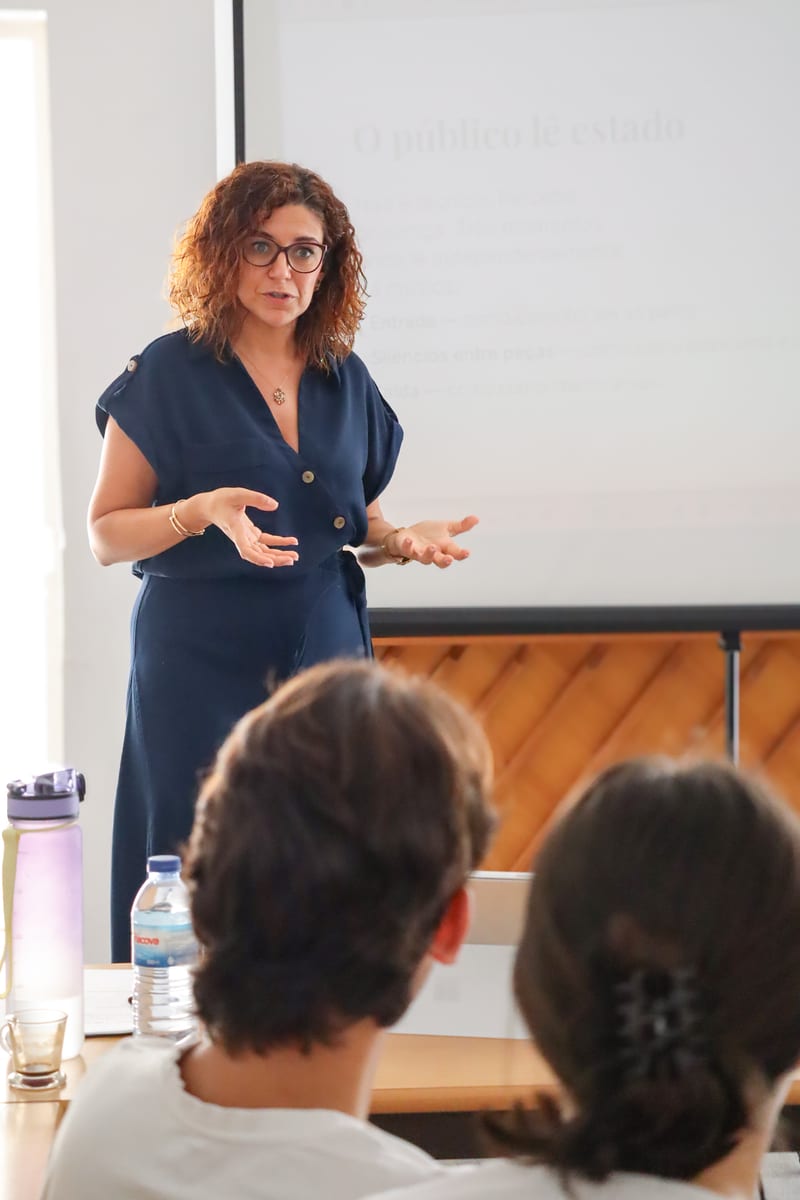 Gabriela Fernandes em contexto de oradora, em pé, sala com público